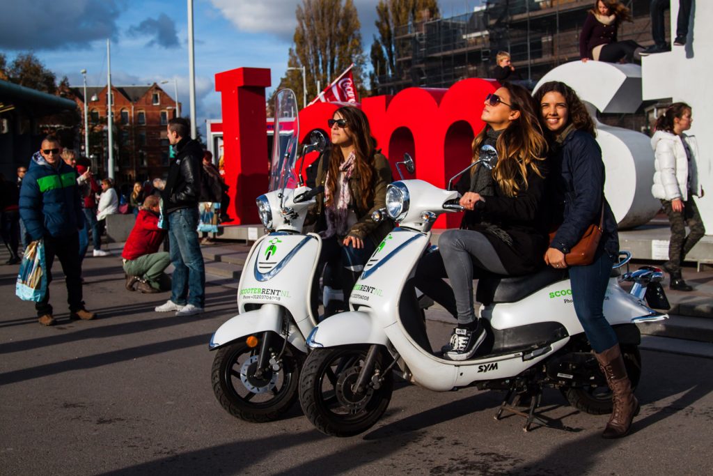 Rental scooters carrying happy girls